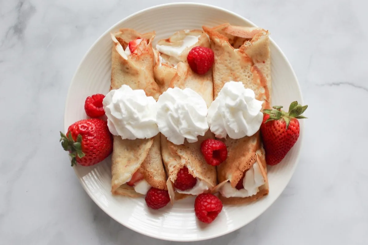 Fruchtige Crepes mit Erdbeeren, Himbeeren und Sahne als Dessert