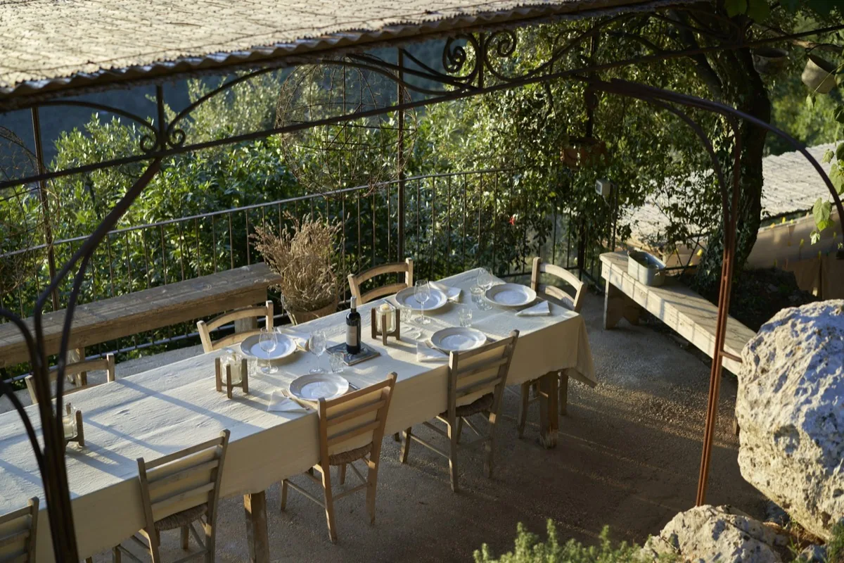 Gedeckter Tisch unter einer Pergola bei einer mediterranen Gartenparty